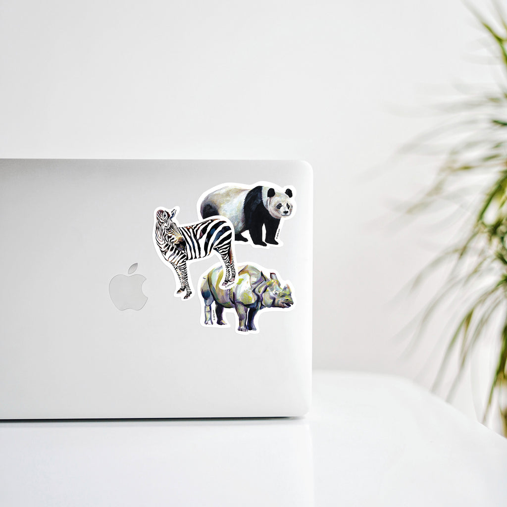 panda, zebra, and rhinoceros stickers decorating a laptop computer