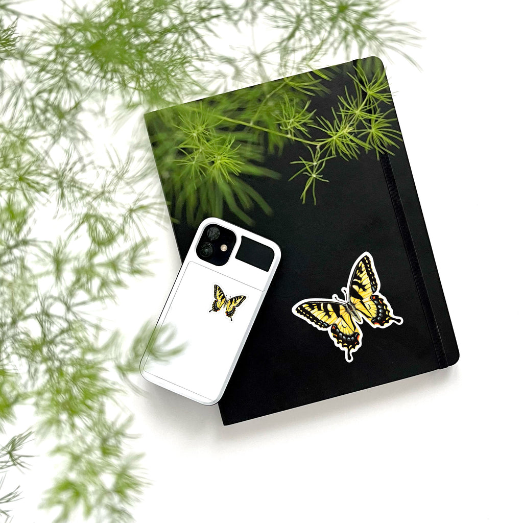 large and small yellow butterfly stickers on phone and notebook