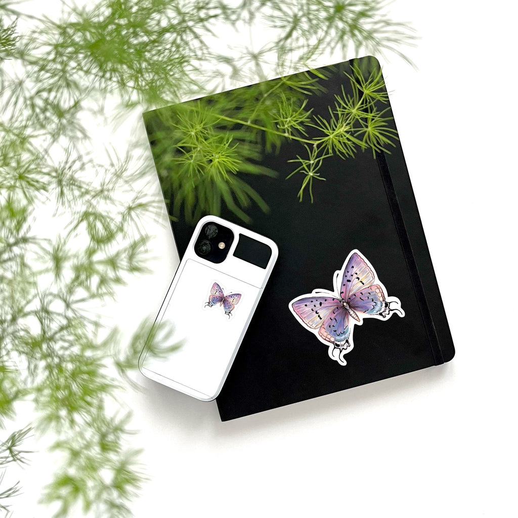 large and small purple butterfly sticker on phone and notebook