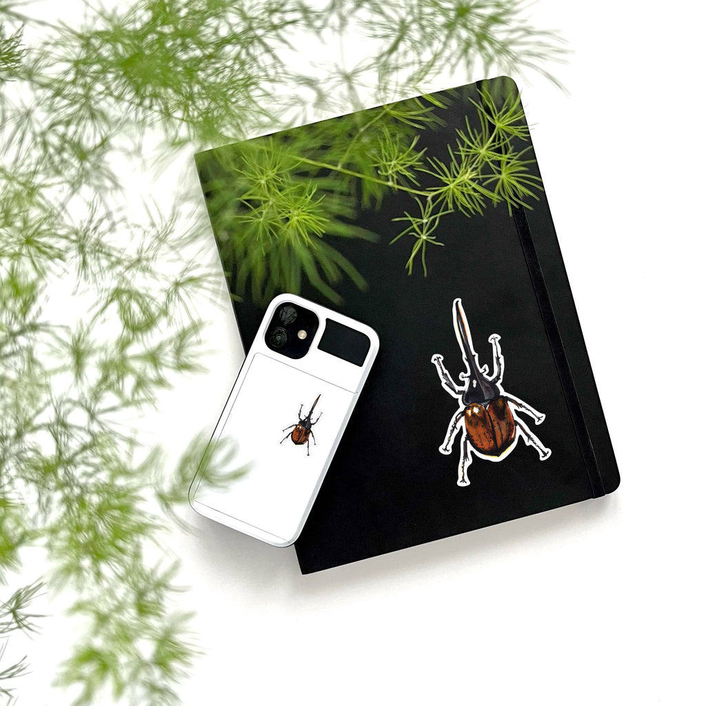 brown hercules beetle vinyl stickers on phone and notebook