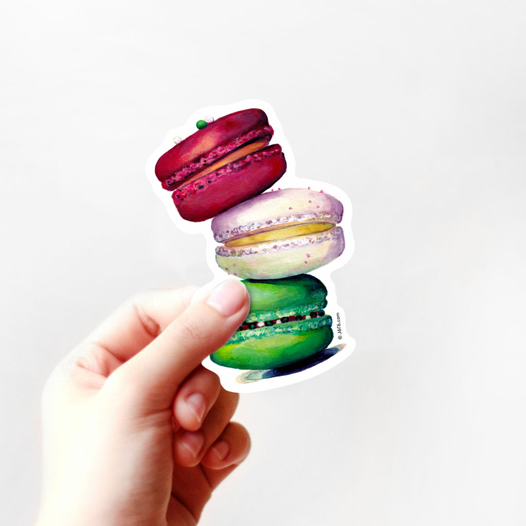 red, white, and green macaron sticker in hand